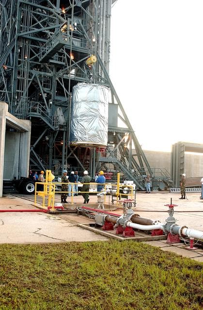 NASA image: KENNEDY SPACE CENTER, FLA.  -  After dawn,  the Space Infrared Telescope Facility (SIRTF) is lifted up the mobile service tower on Launch Pad 17-B, Cape Canaveral Air Force Station.  SIRTF will be attached to the Delta II rocket and encapsulated in its fairing before launch.   Consisting of three cryogenically cooled science instruments and an 0.85-meter telescope, SIRTF is one of NASA’s largest infrared telescopes to be launched.  It is the fourth and final element in NASA’s family of orbiting “Great Observatories.”  SIRTF will obtain images and spectra by detecting the infrared energy, or heat, radiated by objects in space. Most of this infrared radiation is blocked by the Earth's atmosphere and cannot be observed from the ground.