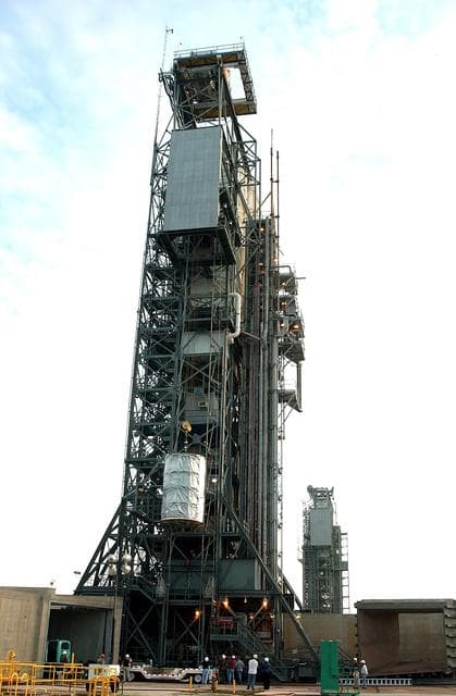 NASA image: KENNEDY SPACE CENTER, FLA.  -  After dawn,  the Space Infrared Telescope Facility (SIRTF) is lifted up the mobile service tower on Launch Pad 17-B, Cape Canaveral Air Force Station.  SIRTF will be attached to the Delta II rocket and encapsulated in its fairing before launch.   Consisting of three cryogenically cooled science instruments and an 0.85-meter telescope, SIRTF is one of NASA’s largest infrared telescopes to be launched.  It is the fourth and final element in NASA’s family of orbiting “Great Observatories.”  SIRTF will obtain images and spectra by detecting the infrared energy, or heat, radiated by objects in space. Most of this infrared radiation is blocked by the Earth's atmosphere and cannot be observed from the ground.