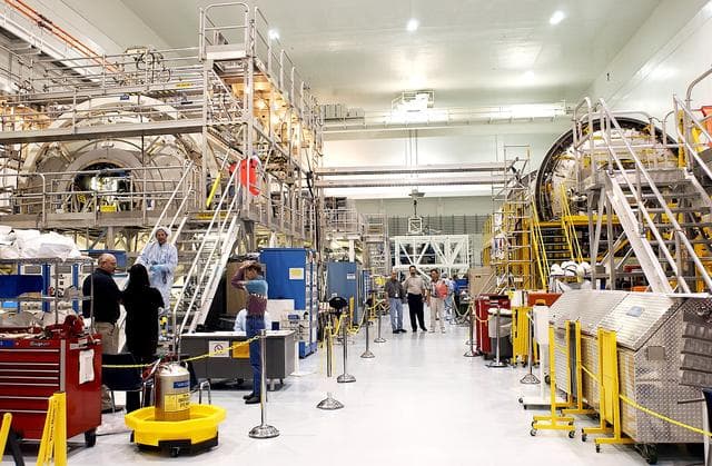NASA image: KENNEDY SPACE CENTER, FLA.  - In the Space Station Processing Facility can be seen the U.S. Node 2 (at left) and the Japanese Experiment Module (JEM)’s Pressurized Module (at right).  The  Italian-built Node 2, the second of three Space Station connecting modules, attaches to the end of the U.S. Lab and will provide attach locations for the Japanese laboratory, European laboratory, the Centrifuge Accommodation Module and, later, Multipurpose Logistics Modules. It will provide the primary docking location for the Shuttle when a pressurized mating adapter is attached to Node 2.  Installation of the module will complete the U.S. Core of the ISS.  Node 2 is the designated payload for mission STS-120.  No orbiter or launch date has been determined yet.  The Pressurized Module is the first element of the JEM to be delivered to KSC. The JEM is Japan's primary contribution to the Station. It will enhance the unique research capabilities of the orbiting complex by providing an additional environment for astronauts to conduct science experiments.  The JEM also includes an exposed facility (platform) for space environment experiments, a robotic manipulator system, and two logistics modules. The various JEM components will be  assembled in space over the course of three Shuttle missions.