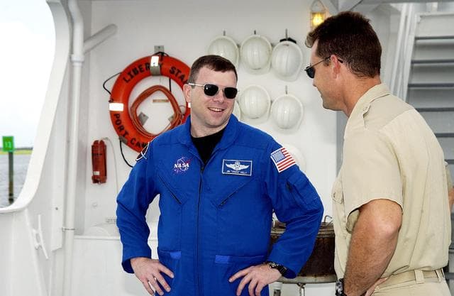 NASA image: KENNEDY SPACE CENTER, FLA. -  STS-114 Pilot James Kelly talks with Bren Wade, captain of the Liberty Star, one of the SRB Retrieval Ships docked at Hangar AF on the Banana River.  Kelly and other crew members Commander Eileen Collins and Mission Specialists  Soichi Noguchi and Stephen Robinson toured the ships.  Noguchi is with the Japanese space agency NASDA.  Mission STS-114 will carry the MultiPurpose Logistics Module (MPLM) Raffaello and External Stowage Platform 2 to the International Space Station.  The MPLM will contain supplies and equipment.  Another goal of the mission is to remove and replace a Control Moment Gyro.  Launch date for mission STS-114 is under review.