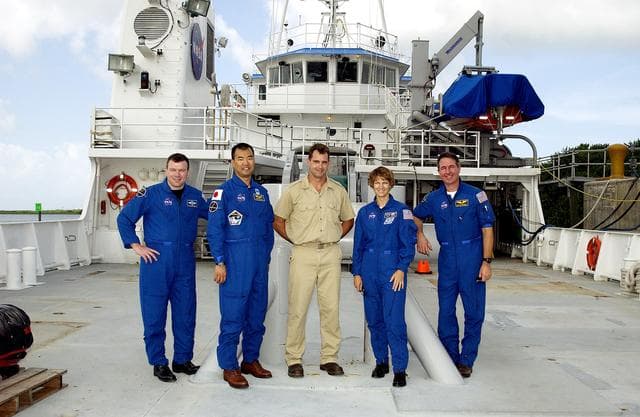NASA image: KENNEDY SPACE CENTER, FLA. -   The STS-114 crew poses on deck with the captain of the Liberty Star, one of the SRB Retrieval Ships docked at Hangar AF on the Banana River.   From left are Pilot James Kelly, Mission Specialist Soichi Noguchi, Capt. Bren Wade, Commander Eileen Collins and Mission Specialist Stephen Robinson.  Noguchi is with the Japanese space agency NASDA.  Mission STS-114 will carry the MultiPurpose Logistics Module (MPLM) Raffaello and External Stowage Platform 2 to the International Space Station.  The MPLM will contain supplies and equipment.  Another goal of the mission is to remove and replace a Control Moment Gyro.  Launch date for mission STS-114 is under review.