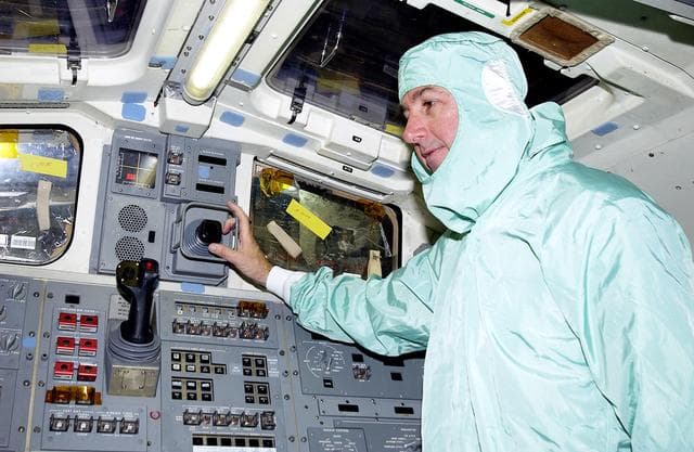 NASA image: KENNEDY SPACE CENTER, FLA. -   STS-114 Mission Specialist Stephen Robinson checks equipment in the flight deck of orbiter Atlantis.  He and other crew members -  Commander Eileen Collins, Pilot James Kelly and Mission Specialist Soichi Noguchi - are at KSC for equipment familiarization.  Noguchi is with the Japanese space agency NASDA.  Mission STS-114 will carry the MultiPurpose Logistics Module (MPLM) Raffaello and External Stowage Platform 2 to the International Space Station.  The MPLM will contain supplies and equipment.  Another goal of the mission is to remove and replace a Control Moment Gyro.  Launch date for mission STS-114 is under review.
