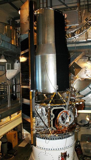 NASA image: KENNEDY SPACE CENTER, FLA.  - In the mobile service tower on Launch Pad 17-B, Cape Canaveral Air Force Station, the Space Infrared Telescope Facility (SIRTF) waits for encapsulation. SIRTF will obtain images and spectra by detecting the infrared energy, or heat, radiated by objects in space. Consisting of a 0.85-meter telescope and three cryogenically cooled science instruments, SIRTF will be the largest infrared telescope ever launched into space. It is the fourth and final element in NASA’s family of orbiting “Great Observatories.” Its highly sensitive instruments will give a unique view of the Universe and peer into regions of space that are hidden from optical telescopes.