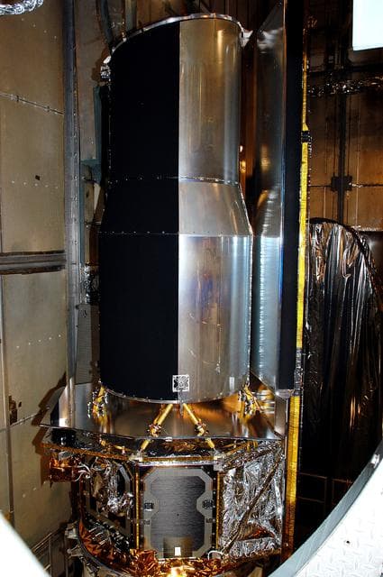 NASA image: KENNEDY SPACE CENTER, FLA.  - In the mobile service tower on Launch Pad 17-B, Cape Canaveral Air Force Station, the Space Infrared Telescope Facility (SIRTF) waits for encapsulation. SIRTF will obtain images and spectra by detecting the infrared energy, or heat, radiated by objects in space. Consisting of a 0.85-meter telescope and three cryogenically cooled science instruments, SIRTF will be the largest infrared telescope ever launched into space. It is the fourth and final element in NASA’s family of orbiting “Great Observatories.” Its highly sensitive instruments will give a unique view of the Universe and peer into regions of space that are hidden from optical telescopes.
