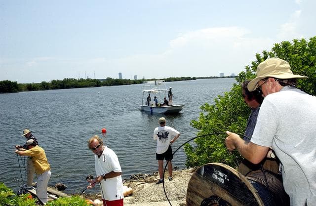 NASA image: KENNEDY SPACE CENTER, FLA.  -  Research team members roll out acoustic cable to the water's edge as others stand by in a watercraft during underwater acoustic research being conducted in the Launch Complex 39 turn basin.  Several government agencies, including NASA, NOAA, the Navy, the Coast Guard, and the Florida Fish and Wildlife Commission are involved in the testing. The research involves demonstrations of passive and active sensor technologies, with applications in fields ranging from marine biological research to homeland security. The work is also serving as a pilot project to assess the cooperation between the agencies involved. Equipment under development includes a passive acoustic monitor developed by NASA’s Jet Propulsion Laboratory, and mobile robotic sensors from the Navy’s Mobile Diving and Salvage Unit.