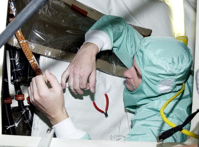 NASA image: KENNEDY SPACE CENTER, FLA.  -   A technician with United Space Alliance checks wiring in the mid-body and flight deck of  orbiter Atlantis as part of routine maintenance.