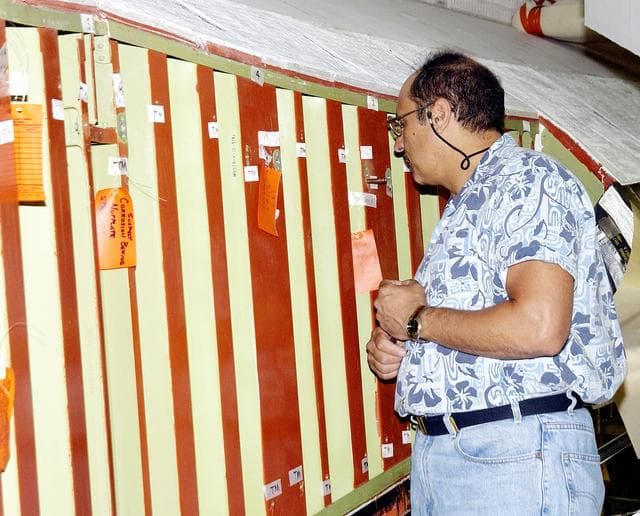 NASA image: KENNEDY SPACE CENTER, FLA. - In the Orbiter Processing Facility (OPF), a United Space Alliance technician examines the attachment points for the spars on the exterior of a wing of Space Shuttle Atlantis. Reinforced Carbon Carbon (RCC) panels are mechanically attached to the wing with a series of floating joints - spars - to reduce loading on the panels caused by wing deflections. The aluminum and the metallic attachments are protected from exceeding temperature limits by internal insulation.  The next launch of Atlantis will be on mission STS-114, a utilization and logistics flight to the International Space Station.