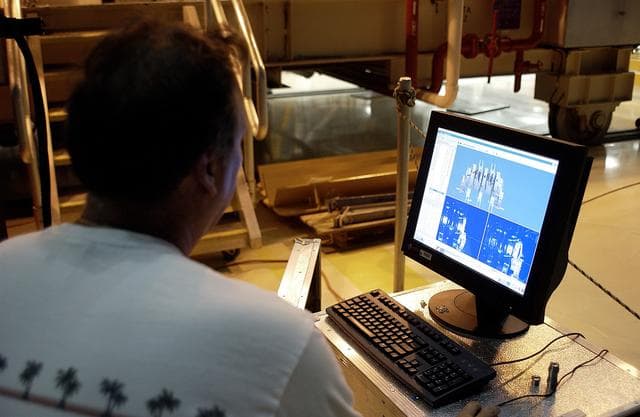 NASA image: KENNEDY SPACE CENTER, FLA. -  In the Orbiter Processing Facility, Boeing worker Alden Pitard looks at a 3D digital scan of an actuator.  There are two actuators per engine on the Shuttle, one for pitch motion and one for yaw motion. The Space Shuttle Main Engine hydraulic servoactuators are used to gimbal the main engine.