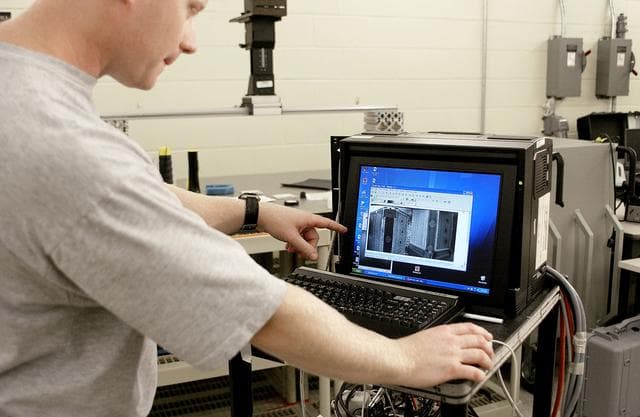 NASA image: KENNEDY SPACE CENTER, FLA. - In the Vehicle Assembly Building, Jim Landy, NDE specialist, examines flight crew lockers using flash thermography.  He is screening the lockers for hidden damage underneath dings and dents that might occur during handling.