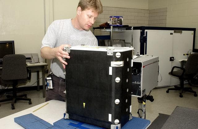 NASA image: KENNEDY SPACE CENTER, FLA. - In the Vehicle Assembly Building, Jim Landy, NDE specialist, sets up a flight crew lockers for flash thermography.  He is screening the lockers for hidden damage underneath dings and dents that might occur during handling.