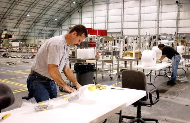 NASA image: KENNEDY SPACE CENTER, FLA. -In the Columbia Debris Hangar, Don Eitel (left) wraps pieces of Columbia debris for storage.  About 83,000 pieces of debris were shipped to KSC during search and recovery efforts in East Texas. That represents about 38 percent of the dry weight of Columbia, equaling almost 85,000 pounds.  An area of the Vehicle Assembly Building is being prepared to store the debris.