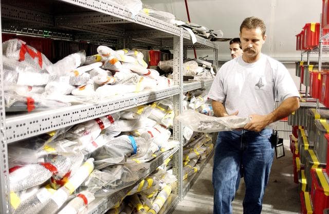 NASA image: KENNEDY SPACE CENTER, FLA. -  In the Columbia Debris Hangar,  Don Eitel (in front) and Jim Delie carry pieces of debris to be packed into storage boxes.  About 83,000 pieces of debris were shipped to KSC during search and recovery efforts in East Texas. That represents about 38 percent of the dry weight of Columbia, equaling almost 85,000 pounds.  An area of the Vehicle Assembly Building is being prepared to store the debris.