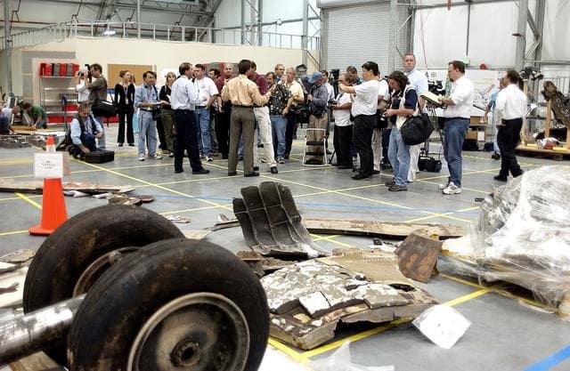 NASA image: KENNEDY SPACE CENTER, FLA. - The media listen to Scott Thurston, NASA vehicle flow manager, talk about efforts to pack the debris stored in the Columbia Debris Hangar.  More than 83,000  pieces of debris were shipped to KSC during search and recovery efforts in East Texas. That represents about 38 percent of the dry weight of Columbia, equaling almost 85,000 pounds. An area of the Vehicle Assembly Building is being prepared to store the debris permanently.