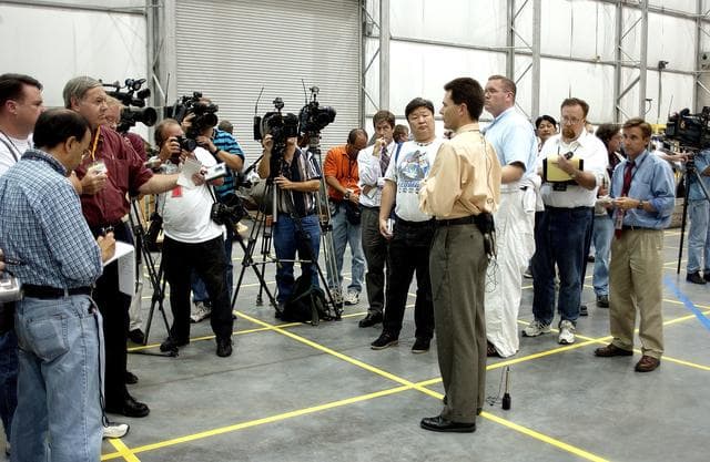 NASA image: KENNEDY SPACE CENTER, FLA. - In the Columbia Debris Hangar, Scott Thurston, NASA vehicle flow manager, addresses the media about efforts to pack the debris stored in the Columbia Debris Hangar.  More than 83,000  pieces of debris were shipped to KSC during search and recovery efforts in East Texas. That represents about 38 percent of the dry weight of Columbia, equaling almost 85,000 pounds. An area of the Vehicle Assembly Building is being prepared to store the debris permanently.