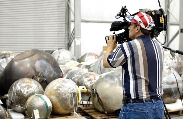 NASA image: KENNEDY SPACE CENTER, FLA. - During a media tour of the Columbia Debris Hangar, a video cameraman records some of the debris collected from search and recovery efforts in East Texas. About 83,000 pieces of debris from Columbia were shipped to KSC, which represents about 38 percent of the dry weight of Columbia, equaling almost 85,000 pounds.  The debris is being packaged for storage in an area of the Vehicle Assembly Building.