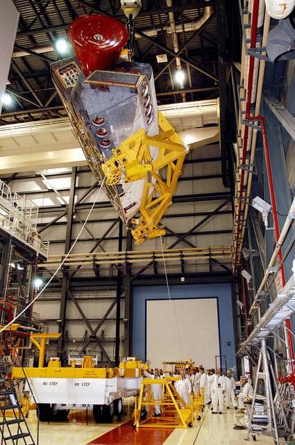 NASA image: KENNEDY SPACE CENTER, FLA. -   In the Orbiter Processing Facility, one of two orbital maneuvering system (OMS) pods removed from Endeavour is suspended overhead.  The OMS pods are attached to the upper aft fuselage left and right sides.  Fabricated primarily of graphite epoxy composite and aluminum, each pod is 21.8 feet long and 11.37 feet wide at its aft end and 8.41 feet wide at its forward end, with a surface area of approximately 435 square feet.  Each pod houses the Reaction Control System propulsion components used for inflight maneuvering and is attached to the aft fuselage with 11 bolts.   OMS pods are removed during Orbiter Major Modifications. Once removed, the OMS pods undergo in-depth structural inspections, system checks and the thrusters are changed out.