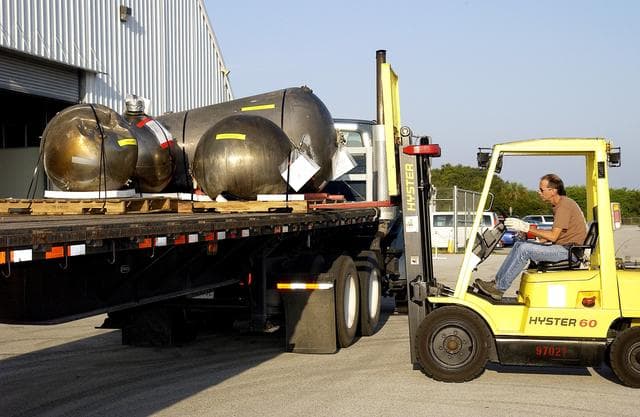 NASA image: KENNEDY SPACE CENTER, FLA. -   Some of the Columbia debris is loaded onto a flatbed truck outside the Columbia Debris Hangar.  The debris is being transferred to the Vehicle Assembly Building for permanent storage.  More than 83,000  pieces of debris were shipped to KSC during search and recovery efforts in East Texas. That represents about 38 percent of the dry weight of Columbia, equaling almost 85,000 pounds.
