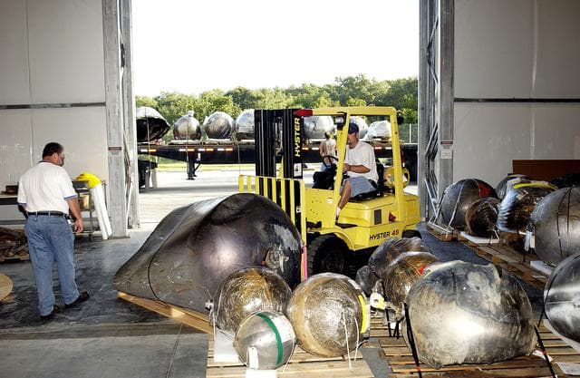 NASA image: KENNEDY SPACE CENTER, FLA. -    Some of the Columbia debris inside the Columbia Debris Hangar is being moved out and placed on a flatbed truck (seen in the background) for transfer to the Vehicle Assembly Building for permanent storage.  More than 83,000  pieces of debris were shipped to KSC during search and recovery efforts in East Texas. That represents about 38 percent of the dry weight of Columbia, equaling almost 85,000 pounds.