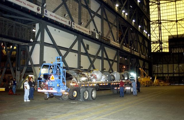 NASA image: KENNEDY SPACE CENTER, FLA.  -  A flatbed truck carrying pieces of Columbia debris  arrives in the transfer aisle of the Vehicle Assembly Building.  The debris is being transferred to the VAB for permanent storage.  More than 83,000  pieces of debris were shipped to KSC during search and recovery efforts in East Texas. That represents about 38 percent of the dry weight of Columbia, equaling almost 85,000 pounds.