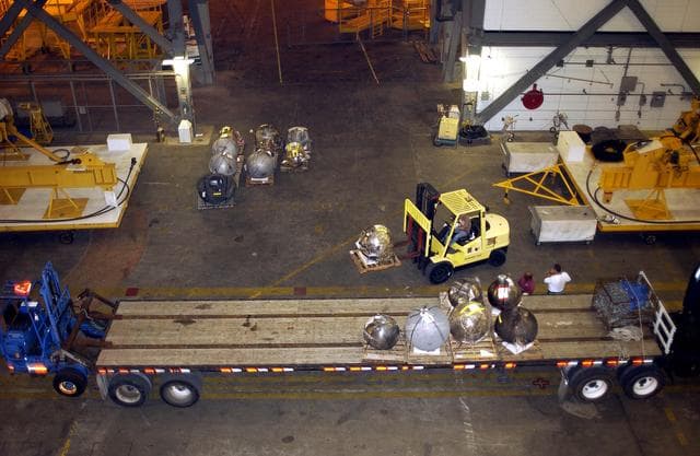 NASA image: KENNEDY SPACE CENTER, FLA. -  Pieces of debris of Space Shuttle Columbia are offloaded from a flatbed truck in the transfer aisle of the Vehicle Assembly Building (VAB).  The debris is being moved from the Columbia Debris Hangar to the VAB for permanent storage.  More than 83,000 pieces of debris were shipped to KSC during search and recovery efforts in East Texas. That represents about 38 percent of the dry weight of Columbia, equaling almost 85,000 pounds.