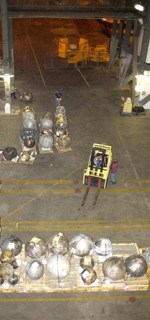 NASA image: KENNEDY SPACE CENTER, FLA. -  Pieces of Columbia debris are offloaded from a flatbed truck in the transfer aisle of the Vehicle Assembly Building (VAB).  The debris is being moved from the Columbia Debris Hangar to the VAB for permanent storage.  More than 83,000 pieces of debris were shipped to KSC during search and recovery efforts in East Texas. That represents about 38 percent of the dry weight of Columbia, equaling almost 85,000 pounds.