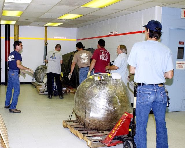 NASA image: KENNEDY SPACE CENTER, FLA. -  Workers move some of the Columbia debris to its storage site in the Vehicle Assembly Building (VAB). The debris is being transferred from the Columbia Debris Hangar to the VAB for permanent storage.  More than 83,000 pieces of debris were shipped to KSC during search and recovery efforts in East Texas. That represents about 38 percent of the dry weight of Columbia, equaling almost 85,000 pounds.