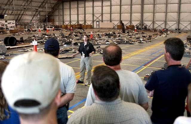 NASA image: KENNEDY SPACE CENTER, FLA.  -  Astronaut Pam Melroy speaks to members of the Columbia Reconstruction Team during transfer of debris from the Columbia Debris Hangar to  its permanent storage site in the Vehicle Assembly Building.  More than 83,000  pieces of debris were shipped to KSC during search and recovery efforts in East Texas. That represents about 38 percent of the dry weight of Columbia, equaling almost 85,000 pounds.