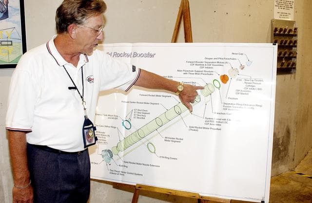 KENNEDY SPACE CENTER, FLA. - On a drawing of a solid rocket booster (SRB), Mark Northcraft, with United Space Alliance, points to the spot where a parachute camera will be installed, on the forward skirt of the SRB.  The work is being done in the Solid Rocket Booster Assembly and Refurbishment Facility, which routinely carries out refurbishment and subassembly of Shuttle SRB hardware.