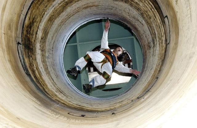 NASA image: KENNEDY SPACE CENTER, FLA. -   Seen from below and through a solid rocket booster segment mockup, Jeff Thon, an SRB mechanic with United Space Alliance, tests the feasibility of a vertical solid rocket booster propellant grain inspection technique.  The inspection of segments is required as part of safety analysis.