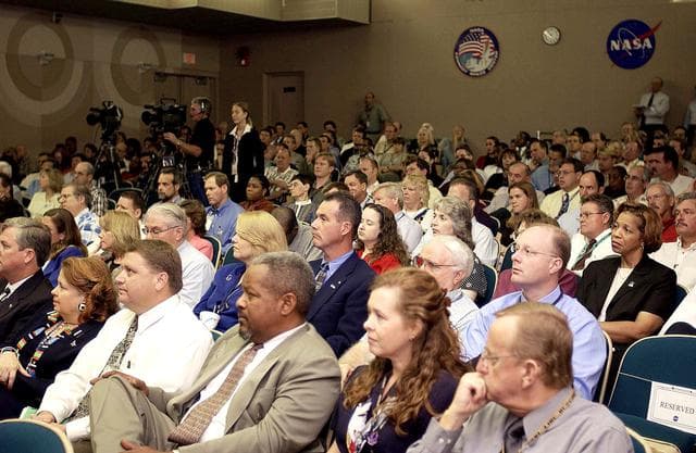 NASA image: KENNEDY SPACE CENTER, FLA. -  Employees in the Training Auditorium listen to  Center Director Jim Kennedy’s first all-hands meeting for employees.  Making presentations were Dr. Woodrow Whitlow Jr., KSC deputy director; Tim Wilson, assistant chief engineer for Shuttle; and Bill Pickavance, vice president and deputy program manager, Florida operations, United Space Alliance.  Representatives from the Shuttle program and contractor team were on hand to discuss the Columbia Accident Investigation Board report and where KSC stands in its progress toward return to flight.