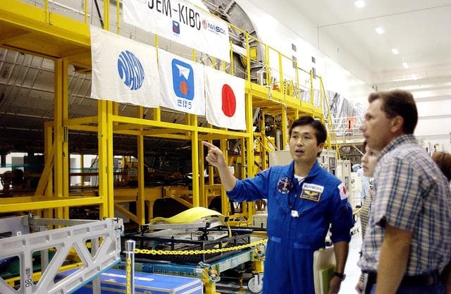 NASA image: KENNEDY SPACE CENTER, FLA. - In the Space Station Processing Facility, Japanese astronaut Koichi Wakata looks over the Pressurized Module, or PM, part of the Japanese Experiment Module (JEM).  The PM provides a shirt-sleeve environment in which astronauts on the International Space Station can conduct microgravity experiments. There are a total of 23 racks, including 10 experiment racks, inside the PM providing a power supply, communications, air conditioning, hardware cooling, water control and experiment support functions.