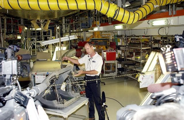 NASA image: KENNEDY SPACE CENTER, FLA. -  In the Orbiter Processing Facility (OPF), Rick Beckwith, an orbiter engineer with United Space Alliance, explains to the media the reinstallation of the Reinforced Carbon-Carbon panels on Atlantis’ wing leading edge.  The media was invited to tour the OPF at KSC and to see the orbiter Atlantis as it is being prepared for Return to Flight.  Both local and national reporters representing print and TV networks were able to see work in progress on Atlantis, also including wiring inspections and checks of the engines in the Orbital Maneuvering System.