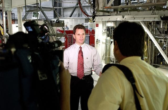 NASA image: KENNEDY SPACE CENTER, FLA. -  NASA Vehicle Manager Scott Thurston talks to the media in the Orbiter Processing Facility.  The media was invited to see the orbiter Atlantis as it is being prepared for Return to Flight.  Both local and national reporters representing print and TV networks were able to see work in progress on Atlantis, including the reinstallation of the Reinforced Carbon-Carbon panels on the orbiter’s wing leading edge; wiring inspections; and checks of the engines in the Orbital Maneuvering System.