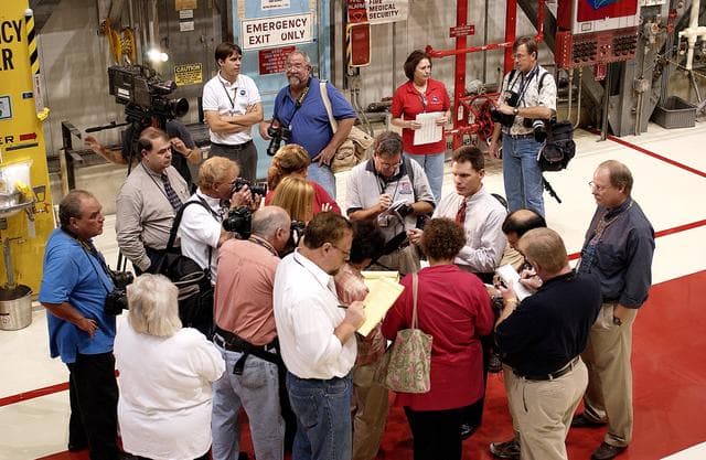 NASA image: KENNEDY SPACE CENTER, FLA. -   The media gather around NASA Vehicle Manager Scott Thurston (white shirt, right) who talks about some of the work being done on the orbiter Atlantis as it is being prepared for Return to Flight in the Orbiter Processing Facility.   Both local and national reporters representing print and TV networks were able to see work in progress on Atlantis, including the reinstallation of the Reinforced Carbon-Carbon panels on the orbiter’s wing leading edge; wiring inspections; and checks of the engines in the Orbital Maneuvering System.