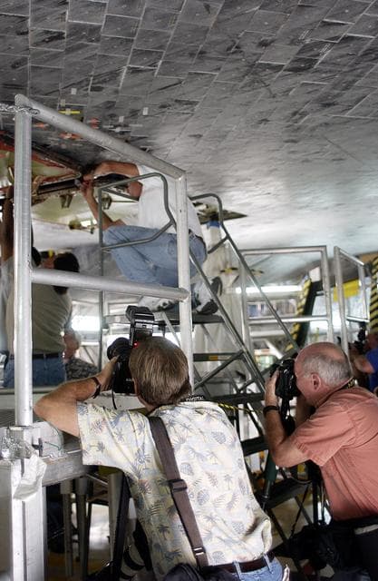 NASA image: KENNEDY SPACE CENTER, FLA. -   In the Orbiter Processing Facility,  the media photograph work being done on the tiles on the orbiter Atlantis as it is being prepared for Return to Flight in the Orbiter Processing Facility.   Both local and national reporters representing print and TV networks were able to see work in progress on Atlantis, including the reinstallation of the Reinforced Carbon-Carbon panels on the orbiter’s wing leading edge; wiring inspections; and checks of the engines in the Orbital Maneuvering System.