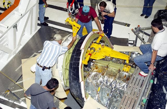 NASA image: KENNEDY SPACE CENTER, FLA. - In the Orbiter Processing Facility, workers remove the nose cone of the orbiter Atlantis for routine inspection. The nose cap is made of reinforced carbon-carbon (RCC), which has an operating range of minus 250° F to about 3,000° F.