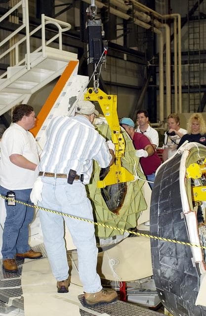 NASA image: KENNEDY SPACE CENTER, FLA. - In the Orbiter Processing Facility, workers secure the nose cap of the orbiter Atlantis for its transfer to a stand.  The cap was removed for routine inspection. The nose cap is made of reinforced carbon-carbon (RCC), which has an operating range of minus 250° F to about 3,000° F.
