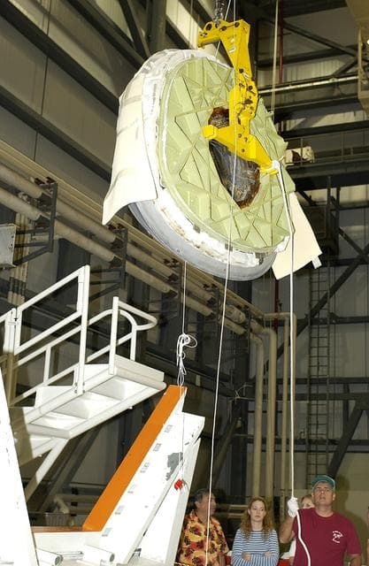 NASA image: KENNEDY SPACE CENTER, FLA. - In the Orbiter Processing Facility, the nose cap of the orbiter Atlantis is lifted for its transfer to a stand.  The cap was removed for routine inspection. The nose cap is made of reinforced carbon-carbon (RCC), which has an operating range of minus 250° F to about 3,000° F.