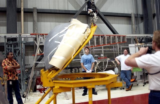 NASA image: KENNEDY SPACE CENTER, FLA. - In the Orbiter Processing Facility, the nose cap of the orbiter Atlantis is shifted to a horizontal position on a stand.  The cap was removed from the orbiter for routine inspection. The nose cap is made of reinforced carbon-carbon (RCC), which has an operating range of minus 250° F to about 3,000° F.