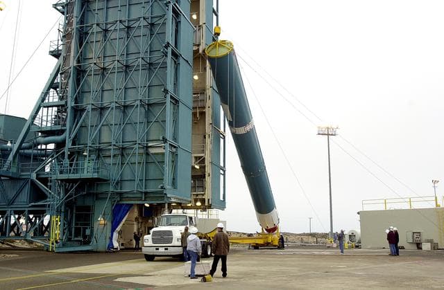 NASA image: VANDENBERG AFB, CALIF. -  The first stage of the Delta II launch vehicle for the Gravity Probe B experiment is raised to a vertical position at Space Launch Complex 2, Vandenberg Air Force Base, Calif.  The Gravity Probe B will launch a payload of four gyroscopes into low-Earth polar orbit to test two extraordinary predictions of Albert Einstein’s general theory of relativity: the geodetic effect (how space and time are warped by the presence of the Earth) and frame dragging (how Earth’s rotation drags space and time around with it). Once in orbit, for 18 months each gyroscope’s spin axis will be monitored as it travels through local spacetime, observing and measuring these effects.  The experiment was developed by Stanford University, Lockheed Martin and NASA’s Marshall Space Flight Center.  The targeted launch date is Dec. 6, 2003.