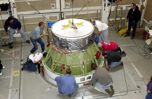 NASA image: VANDENBERG AFB, CALIF. - Workers on the mobile service tower at Space Launch Complex 2, Vandenberg Air Force Base, Calif., check the Delta II rocket’s second stage as it is mated with the first stage. The Delta II is the launch vehicle for the Gravity Probe B experiment, developed by Stanford University, Lockheed Martin and NASA’s Marshall Space Flight Center.   The Gravity Probe B will launch a payload of four gyroscopes into low-Earth polar orbit to test two extraordinary predictions of Albert Einstein’s general theory of relativity: the geodetic effect (how space and time are warped by the presence of the Earth) and frame dragging (how Earth’s rotation drags space and time around with it). Once in orbit, for 18 months each gyroscope’s spin axis will be monitored as it travels through local spacetime, observing and measuring these effects. The targeted launch date is Dec. 6, 2003.