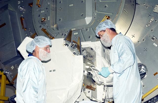 NASA image: KENNEDY SPACE CENTER, FLA. -  In the Space Station Processing Facility, STS-117 Mission Specialist James Reilly (left) and STS-115 Mission Specialist Joseph Tanner (right) look over components in the Japanese Experiment Module (JEM).  Equipment familiarization is a routine part of astronaut training and launch preparations.