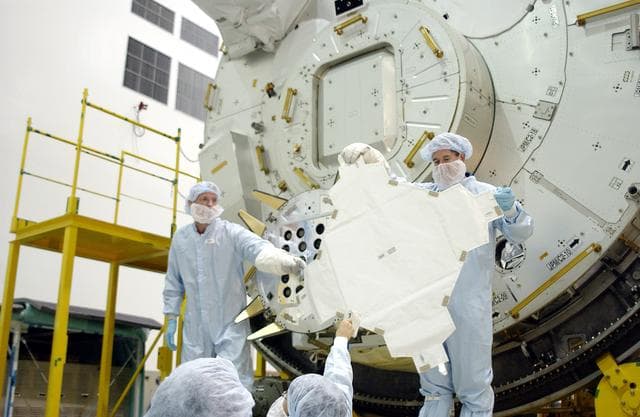 NASA image: KENNEDY SPACE CENTER, FLA. - In the Space Station Processing Facility, STS-115 Mission Specialist Joseph Tanner (left) and STS-117 Mission Specialist James Reilly (right) remove a cover from the Exposed Facility Berthing Mechanism (EFBM) on the Japanese Experiment Module (JEM) behind them. Equipment familiarization is a routine part of astronaut training and launch preparations.