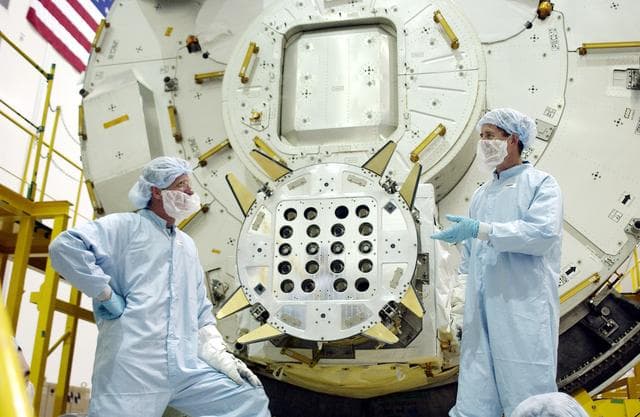 NASA image: KENNEDY SPACE CENTER, FLA. - In the Space Station Processing Facility, STS-115 Mission Specialist Joseph Tanner (left) and STS-117 Mission Specialist James Reilly (right) talk after removing a cover from the Exposed Facility Berthing Mechanism (EFBM) on the Japanese Experiment Module (JEM) behind them. Equipment familiarization is a routine part of astronaut training and launch preparations.