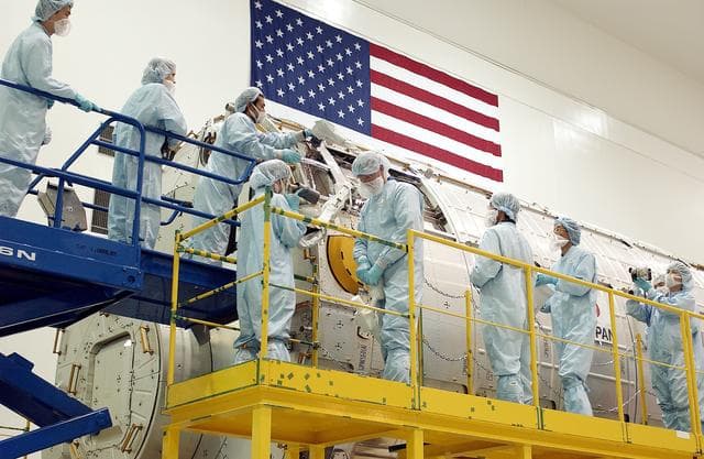NASA image: KENNEDY SPACE CENTER, FLA. - In the Space Station Processing Facility, STS-115 Mission Specialist Joseph Tanner (second from left, foreground) works with technicians to learn more about the Japanese Experiment Module (JEM), known as Kibo.  The JEM consists of six components: two research facilities - the Pressurized Module and the Exposed Facility; a Logistics Module attached to each of them; a Remote Manipulator System; and an Inter-Orbit Communication System unit. Kibo also has a scientific airlock through which experiments are transferred and exposed to the external environment of space. The various components of JEM will be assembled in space over the course of three Space Shuttle missions. Equipment familiarization is a routine part of astronaut training and launch preparations.