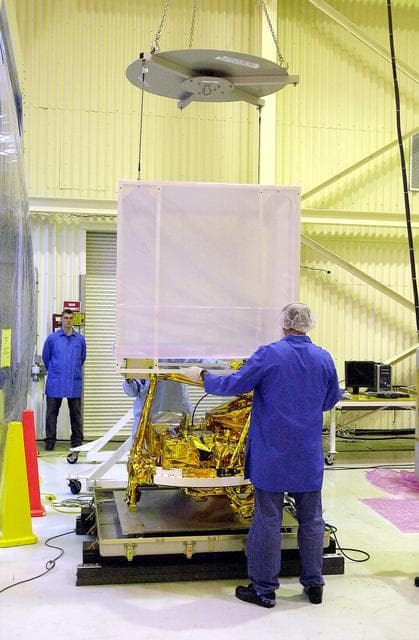 NASA image: VANDENBERG AIR FORCE BASE, CALIF.- The cover is being lifted off SciSat-1 spacecraft at Vandenberg Air Force Base, Calif.   Sci-Sat, which will undergo instrument checkout and spacecraft functional testing, weighs approximately 330 pounds and after launch will be placed in a 400-mile-high polar orbit to investigate processes that control the distribution of ozone in the upper atmosphere. The data from the satellite will provide Canadian and international scientists with improved measurements relating to global ozone processes and help policymakers assess existing environmental policy and develop protective measures for improving the health of our atmosphere, preventing further ozone depletion. The mission is designed to last two years.