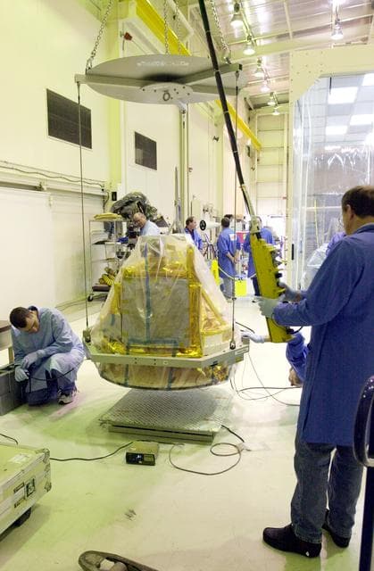NASA image: VANDENBERG AIR FORCE BASE, CALIF.-  The covered SciSat-1 spacecraft is lowered onto a test stand at Vandenberg Air Force Base, Calif., for functional testing.  The solar arrays will be attached and the communications systems checked out.   The SciSat-1 weighs approximately 330 pounds and after launch will be placed in a 400-mile-high polar orbit to investigate processes that control the distribution of ozone in the upper atmosphere. The data from the satellite will provide Canadian and international scientists with improved measurements relating to global ozone processes and help policymakers assess existing environmental policy and develop protective measures for improving the health of our atmosphere, preventing further ozone depletion. The mission is designed to last two years.
