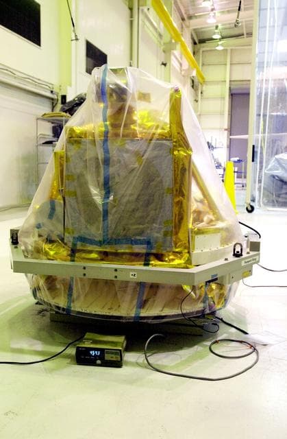 NASA image: VANDENBERG AIR FORCE BASE, CALIF.-  A covered SciSat-1 spacecraft sits on a test stand at Vandenberg Air Force Base, Calif.  The solar arrays will be attached and the communications systems checked out.   The SciSat-1 weighs approximately 330 pounds and after launch will be placed in a 400-mile-high polar orbit to investigate processes that control the distribution of ozone in the upper atmosphere. The data from the satellite will provide Canadian and international scientists with improved measurements relating to global ozone processes and help policymakers assess existing environmental policy and develop protective measures for improving the health of our atmosphere, preventing further ozone depletion. The mission is designed to last two years.