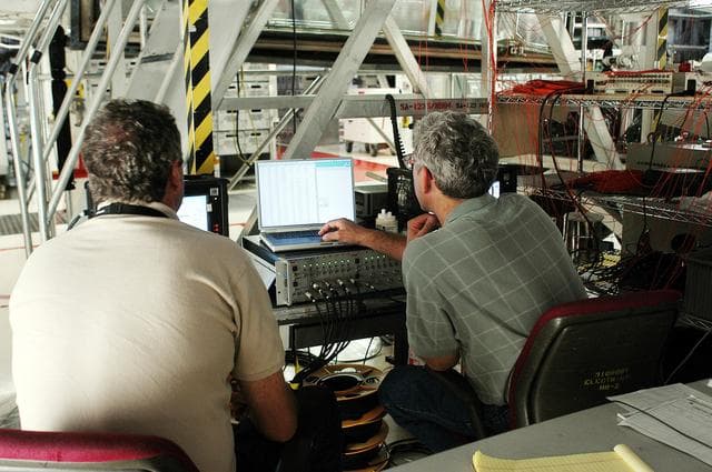 NASA image: KENNEDY SPACE CENTER, FLA. -  In the Orbiter Processing Facility, Bill Prosser (left) and Eric Madaras, NASA-Langley Research Center, conduct impulse tests on the right wing leading edge (WLE) of Space Shuttle Endeavour. The tests monitor how sound impulses propagate through the WLE area.  The data collected will be analyzed to explore the possibility of adding new instrumentation to the wing that could automatically detect debris or micrometeroid impacts on the Shuttle while in flight.  The study is part of the initiative ongoing at KSC and around the agency to return the orbiter fleet to flight status.