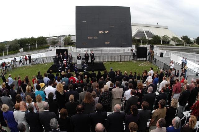 NASA image: KENNEDY SPACE CENTER, FLA. -  Family members of the STS-107 astronauts and other dignitaries attend a dedication ceremony at the Space Mirror Memorial at the Kennedy Space Center Visitor Complex.  During this solemn event, the names of the STS-107 astronauts who lost their lives during the Columbia accident -- Rick Husband, Willie McCool, Laurel Clark, Michael Anderson, David Brown, Kalpana Chawla, and Ilan Ramon -- join the names of 17 other space heroes who gave their lives for the U.S. space program. The "Space Mirror," 42 1/2 feet high by 50 feet wide, illuminates the names of the fallen astronauts cut through the monument's black granite surface.